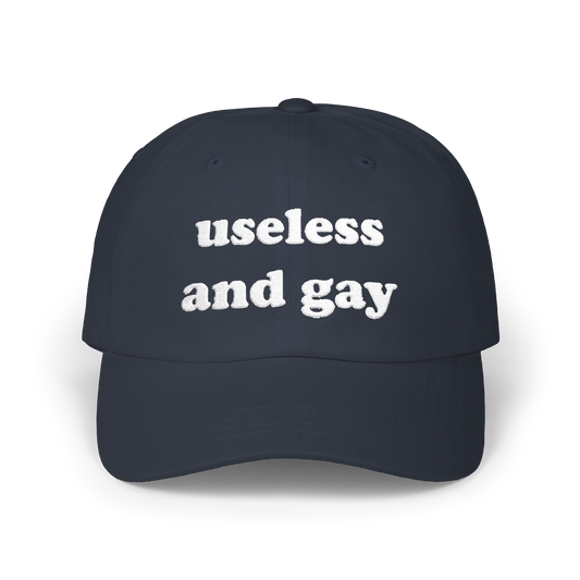 Navy dad hat with "useless and gay" embroidered in white on the front panel