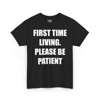 Black t-shirt with "FIRST TIME LIVING. PLEASE BE PATIENT" printed in white on the chest