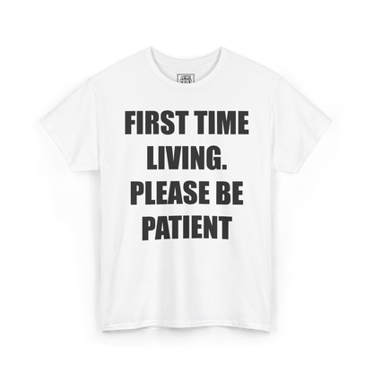 White t-shirt with "FIRST TIME LIVING. PLEASE BE PATIENT" printed in black on the chest