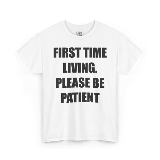 White t-shirt with "FIRST TIME LIVING. PLEASE BE PATIENT" printed in black on the chest