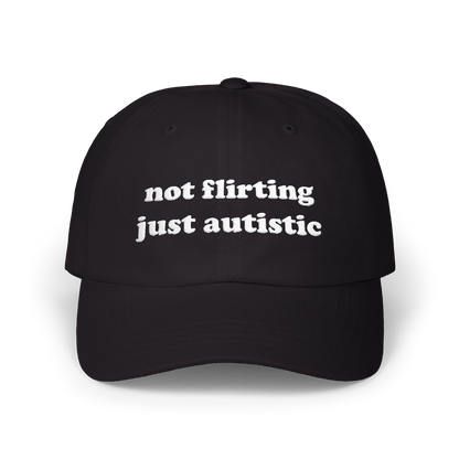 Black dad hat with "not flirting just autistic" embroidered in white on the front panel