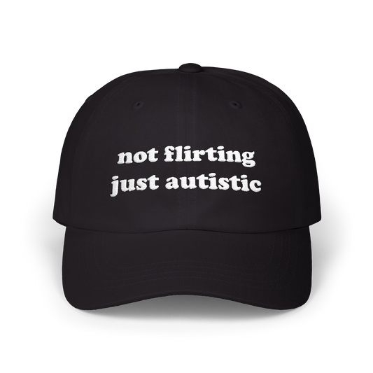 Black dad hat with "not flirting just autistic" embroidered in white on the front panel