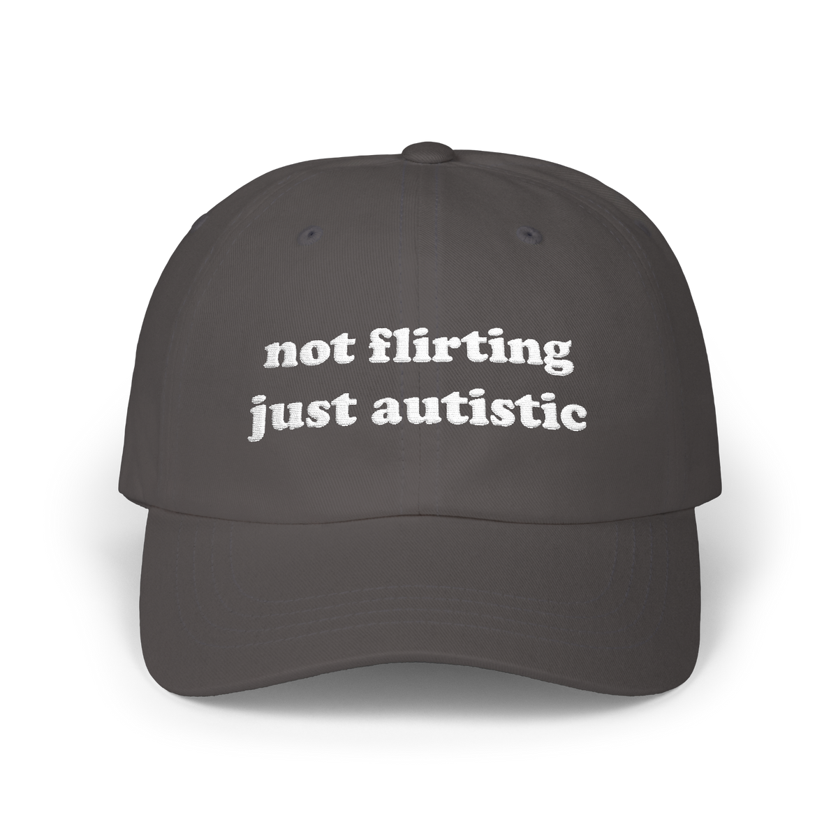 Dark grey dad hat with "not flirting just autistic" embroidered in white on the front panel