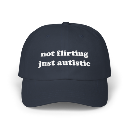 Navy dad hat with "not flirting just autistic" embroidered in white on the front panel