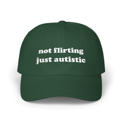 Spruce green dad hat with "not flirting just autistic" embroidered in white on the front panel